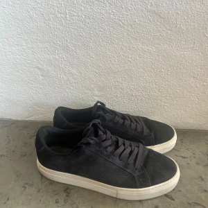 Mörkblåa mockasneakers från Vagabond - Stilrena mörkblåa sneakers från Vagabond i mjuk mocka med vita platta sulor. Klassisk design med rund tå och snörning framtill. Perfekta för en clean och avslappnad look.