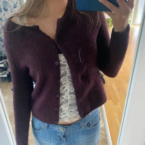 Mörkröd/vinröd kofta cardigan från Gina Tricot - Supermysig mörkröd/vinröd kofta/cardigan från Gina Tricot. Klassisk rak modell med rund halsringning och knappar hela vägen framtill. Perfekt att slänga över ett linne eller t-shirt för en chill look.