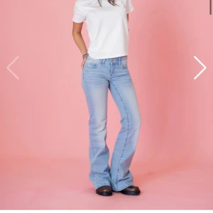 Ljusblå bootcut jeans med broderi - Säljer ett par ljusblå bootcut jeans med snyggt rosa broderi på bakfickorna från din vintage shop. De är helt oanvända då jag var för snabb med att ta bort lappen men de var för små tyvärr. 