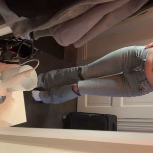 Ljusblå bootcut jeans med slitningar - Säljer ett par ljusblå jeans med bootcut-modell och snygga slitningar vid knäna. Jeansen har klassisk femficksdesign, normal passform och är tillverkade i denim. Perfekta för dig som gillar en avslappnad och trendig look. Har lite märken där bak längst ner då dom varit för långa 