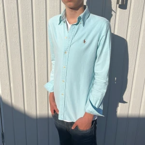 Ljusblå Ralph Lauren Skjorta - Tja! Säljer nu denna galet feta Ralph Lauren Skjortan! Toppskick utan några defekter, 9/10! Färgen är Ljusblå/Turkos, riktigt fet nu när solen skiner!☀️Storlek S, Fits=S Slim fit. Äkta med supplier number, 100% bomull! Hör av dig vid minsta fråga eller fundering!🌟