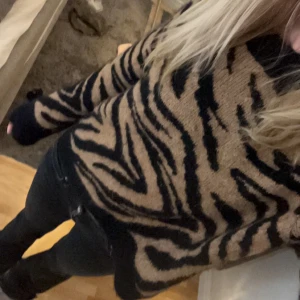 Zebramönstrad stickad tröja - Säljer en snygg stickad tröja med zebramönster i beige och svart. Tröjan är i ett jätte mysigt och lent matrial💕