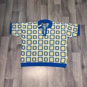 Retro summer knit pikétröja med blå och gula rutor - Färgglad pikétröja från MRP med blå krage och ärmslut. Tröjan har ett rutigt mönster i blått, gult och vitt, samt korta ärmar. Perfekt för dig som gillar unika och retroinspirerade plagg med skön passform.