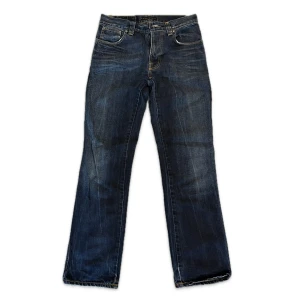 Mörkblå lågmidjade jeans från Nudie Jeans W31 L32 - Säljer ett par mörkblå lågmidjade jeans från Nudie Jeans med klassisk femficksdesign och snygga slitningar. 