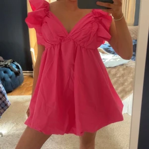 Klänning - Superfin neonrosa miniklänning med volanger! Storlek M.