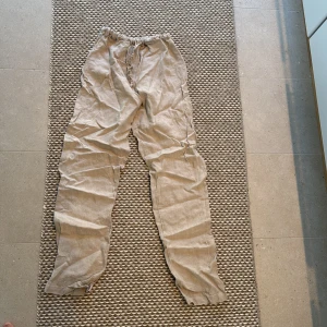 Beige linnebyxor från Lin Living - Säljer ett par bekväma beige linnebyxor från Lin Living. Byxorna har en elastisk midja för extra komfort och är perfekta för varma dagar. De är designade i Sverige och tillverkade av högkvalitativt, kraftigt linne.