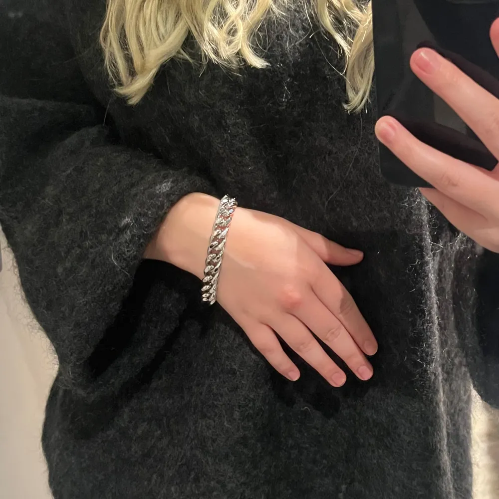 Unikt silverfärgat vintage armband med en robust kedjedesign. Perfekt för att ge en stilren touch till din outfit. Armbandet har en unik låsdetalj som ger det en extra edge.. Asusteet.