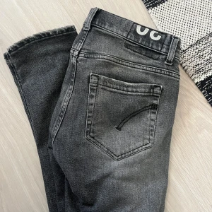 Dondup George - Säljer ett par grå dondup jeans med coola slitningar på framsidan. Modell george strl 30 och är perfekta för en avslappnad stil. Jeansen är tillverkade i ett bekvämt material.