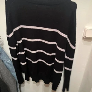 Svart och vit randig tröja från BikBok - Säljer en svart tröja från BikBok med vita ränder. Tröjan har långa ärmar och en klassisk passform. Perfekt för en stilren look.