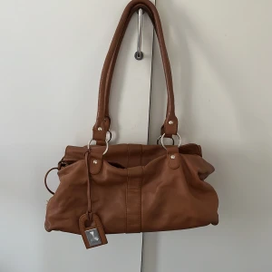 Väska från Laura Clement - Brun väska från Laura Clement. (Första bilden är tagen från internet, resterande är mina) 