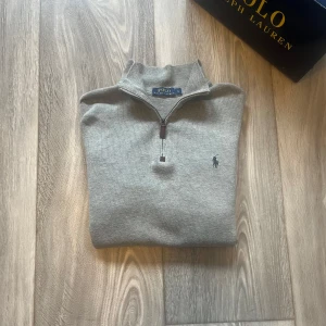 Grå tröja med dragkedja från Polo Ralph Lauren - Säljer en stilren grå tröja från Polo Ralph Lauren med halv dragkedja och broderad logga på bröstet. Den är i 10/10 skick. Fråga om du har några frågor 