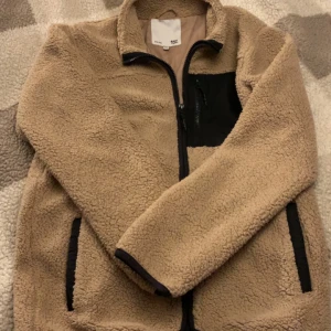 Beige teddyjacka från 157 - Mysig beige teddyjacka från 157 med dragkedja och svarta detaljer. Den är i storlek 160 men passar också personer som har S, köparen står för frakten💕
