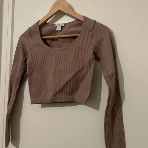 Brun biege  ribbad croppad topp  - Säljer en snygg brun biege ribbad topp från New yorker. Den är croppad med långa ärmar