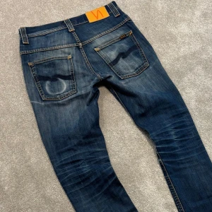 Nudie jeans - Tja! Säljer dessa mörkblå/blå Nudie jeans med stört najs tvätt! Jeansen är i perfekt condition, som nya! Slimfit passform. Size 28/34 men de är som 28/32, ytterbenslängden är 105cm. Skriv vid funderingar!