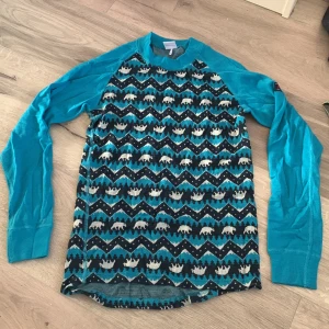 Blå mönstrad tröja från Polarn O. Pyret - Säljer en cool blå tröja från Polarn O. Pyret med ett unikt mönster av björnar och sicksacklinjer. Tröjan har långa ärmar och är perfekt för kyligare dagar. Passar barn i åldern 10-12 år.