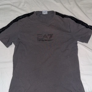 Ea7 T-Shirt - Ea7 T-Shirt i färgen mörk grå. Mycket fin.