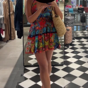 Färgglad klänning med volanger - Säljer min super söta klänning som går att användas som kjol enligt bild två. Knyts i nacken! Passar xs-m! Jättefin och perfekt nu till sommaren! Köpt i Italien! Använd ett fåtal gånger