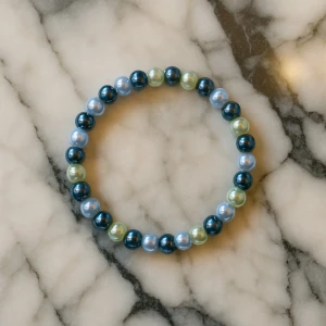 Flerfärgat pärlarmband - Snyggt armband med pärlor i blå, gröna och ljusblå nyanser. Perfekt accessoar för att ge en färgklick till din outfit. Elastiskt band för enkel passform.