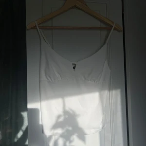 Vitt linne - Ett vitt linne från Bikbok i storlek m. Passar dock även som s beroende på önskad passform. Den är lite nopprig (bild 3) men annars sparsamt använd. 