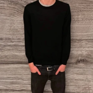 Svart långärmad tröja - Säljer en stilren svart långärmad tröja med rund hals. Perfekt för en minimalistisk look och kan enkelt matchas med olika outfits. Passar både till vardag och mer uppklädda tillfällen.