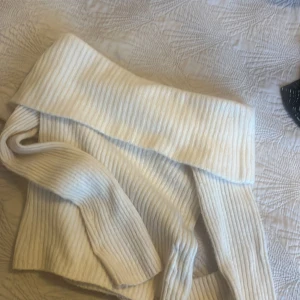 Vit tjocktröja - Säljer en stilren vit ribbad polotröja med en bred krage. Perfekt för kyligare dagar och lätt att matcha med olika outfits. Tröjan har långa ärmar och är gjord i ett mjukt material. Jag säljer den för att jag knappast använder.