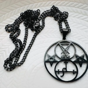 Nytt svart halsband i rostfritt stål med pentagram & Lucifers & Lilths sigill Ockult Wicca Metal Punk  - Svart halsband i blankt rostfritt stål med kraftfull symbolik. Hängsmycket pryds av pentagram, Lucifers sigill och Liliths sigill – starka symboler som ofta förknippas med självständighet, transformation och andlig kraft.  Kedjan är ca 58 cm lång och hängsmycket mäter ca 4,5 × 3,5 cm. Halsbandet är helt nytt och passar perfekt för dig med alternativ, gotisk eller rockig stil.  Ingen prutning – men bundlerabatt erbjuds vid köp av flera plagg.