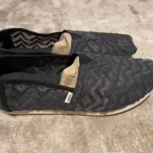 Svarta skor från Toms - Säljer ett par svarta skor från Toms. De är perfekta för en avslappnad och somrig stil. Aldrig använda och i modellen Alpargata. Storlek 6 men invändig sula mäter 23 cm. 💗💗