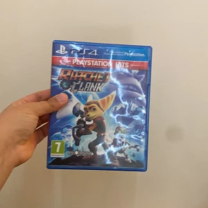 Ratchet & Clank för PS4 - Säljer spelet Ratchet & Clank för PS4. Det är en del av PlayStation Hits-serien och har en åldersgräns på 7 år. Perfekt för fans av action och äventyr. Skivan är i ett blått fodral med färgglad grafik på omslaget.