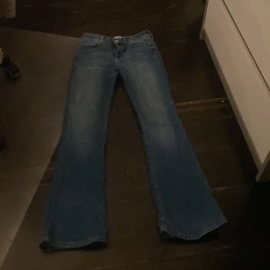 Blå jeans från ONLY - Säljer ett par klassiska blå jeans från ONLY. De har en bootcut-stil och är tillverkade i jeansmaterial. Byxorna har en dragkedja och knapp framtill samt fem fickor. Dem är stretchiga och väldigt skönt material, jag säljer dessa för jag använder dom aldrig !💘