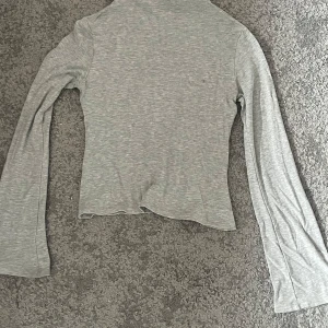 Grå långärmad tröja XS - Säljer en stilren grå tröja med vida armar nedtill och liten krage från lager 157 i storlek XS 