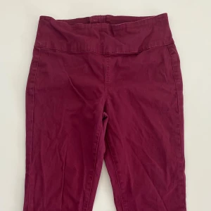 Vinröda byxor från Pieces - Snygga vinröda byxor från Pieces med hög midja och dragkedja bak. Byxorna har en slim passform och är perfekta för en stilren look. De är tillverkade i ett bekvämt material som ger en skön känsla hela dagen.