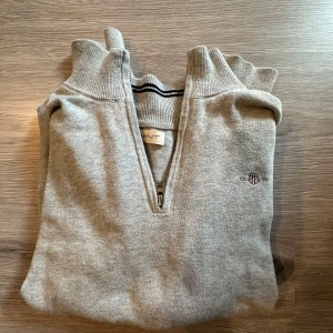 Grå tröja med dragkedja från Gant - Snygg och stilren grå tröja från Gant med dragkedja vid halsen. Nypris 999kr