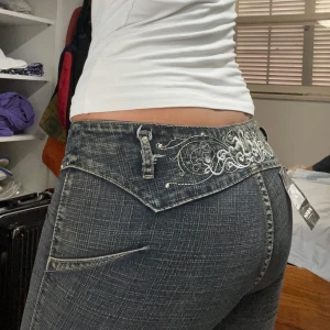 Lågmidjade jeans - Så coola bootcut jeans med diamanter och möster, inga bakfickor!! Dom är köpta utomlands och är i nyskick, tyvärr har dragkedjan gått sönder men det syns inte så tydligt när man använder dom. Om man vill går det säkert att laga hos en skräddare också! Jag är 165cm och dom passar en XS eller liten S. Midjemåttet rakt över är 38cm (+ strech!!!), innerbenslängden är 80cm, midjehöjden framifrån är 19cm <3