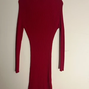 Röd ribbad långärmad klänning Bik Bok - Snygg röd ribbad klänning från Bik Bok i storlek L. Klänningen är figurnära med lång ärm och har en stretchig känsla tack vare materialmixen av viskos och nylon. Perfekt för dig som gillar en tight och stilren look.