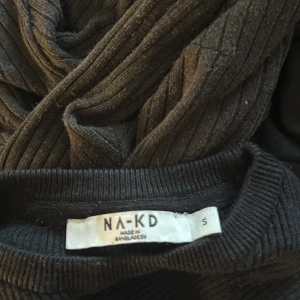 Svart ribbad långärmad tröja NA-KD - Säljer en svart ribbad långärmad tröja från NA-KD i storlek S. Tröjan har en tight passform och är tillverkad i ett stretchigt material som sitter snyggt på kroppen. Perfekt basplagg med rund hals och diskret struktur. 💕