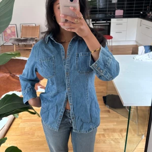 Klassisk jeansskjorta med fickor - Jeansskjorta med knappar som man kan bära öppen eller stängd. Storlek 42, men jag har 36 - 38 och den passar mig fint!