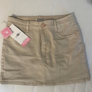 Beige jeanskjol från Missay - Stilren beige jeanskjol från Missay med prislapp kvar som är helt oanvänd! Jättesäker att gå i eftersom den har en inbyggd innekjol!💕