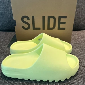 Adidas Yeezy Slide Glow Green - Adidas Slide Glow Green. Helt oanvända, storlek 44 1/2. Små i storleken, passar till dem som har 42-43. Köpta från Adidas Confirmed appen så kvitto mm finns. 