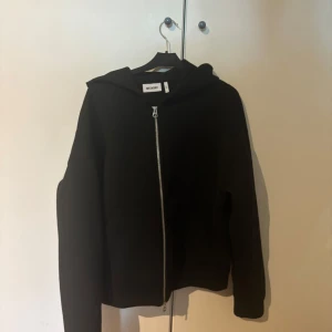 Svart hoodie med dragkedja från Weekday - Svart hoodie från Weekday i storlek M med hel dragkedja framtill. Knappt använd, skicket är 9/10