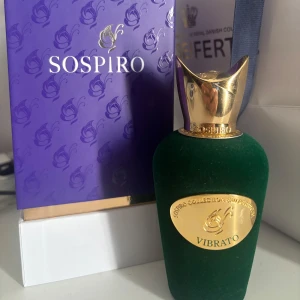 Sospiro Vibrato parfym - Lyxig parfym från Sospiro i modellen Vibrato. Flaskan är klädd i mörkgrönt sammet med guldfärgade detaljer och en elegant, skulptural guldkork. Kommer i en snygg lila ask med gulddetaljer. Perfekt för dig som gillar exklusiva dofter och snygg design. Ungefär 90ML kvar. 