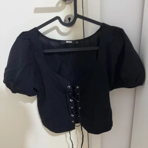 Svart topp - En svart topp från BikBok i stl xs som är i väldigt bra skick säljs för 50 kr. 