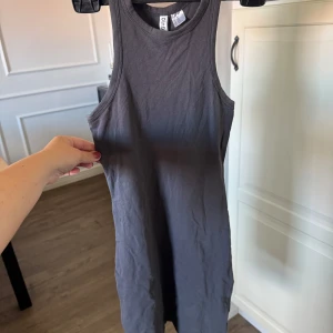 Mörkgrå ärmlös klänning - Säljer en enkel och stilren mörkgrå klänning.