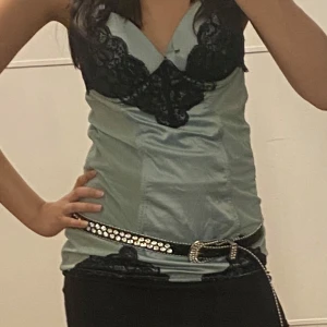 Mintgrön spetslinnetopp med öppen rygg - Supersnygg mintgrön linnetopp med svarta spetsdetaljer och v-ringning. Toppen har smala axelband och en öppen rygg med spetskant. Sidenliknande material och toppen är lång. Lite korsett aktig. Kupan är 85 o för stort för mig! Skriv vid frågor🫶🏽toppen är från beyond retro