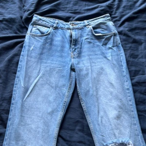 Ljusblå jeans från Gina , strl 42 - Säljer ett par ljusblå jeans från g perfect jeans i storlek 42. Jeansen har klassisk femficksdesign, raka ben och slitna detaljer med hål och fransar vid knäet. Perfekta för en avslappnad och trendig look. Små i storlek! Priset är ej satt! (Mid waste)