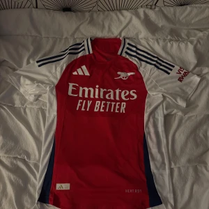 Arsenal hemmatröja Adidas röd/vit - Snygg Arsenal hemmatröja med klassisk röd front och vita ärmar. Tröjan är i nyskick och säljs då den var lite för stor för mig. Storlek M