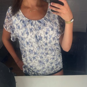 Blommig spetsblus i blått och vitt, isolde - Söt blus med blommigt mönster i blått och vitt. Den är i storlek L men skulle säga att den passar lite mindre storlekar också! skriv för frågor!