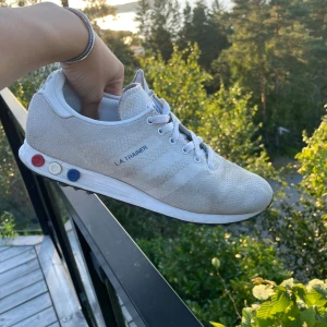 Vita la trainers - Säljer mina vit/blå/röda la trainers. De är smutsiga och därav priset. Storlek 43 och en tredjedel men passar 42,5/43.Kommer hem 2 augusti (lördag) så kontakta innan du köper‼️