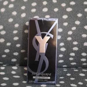 Yves Saint Laurent Y Eau de Parfum 100ml - Yves Saint Laurent Y Eau de Parfum i 100ml flaska. Snygg, stilren design med svart och transparent glasflaska, svart texturerad kork och silverdetaljer. Doften är modern och maskulin, perfekt för dig som gillar exklusiva parfymer med karaktär.