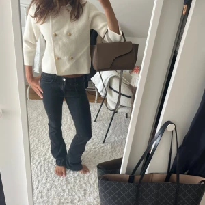 Svarta lågmidjade jeans - Säljer ett par svarta jeans med bootcut passform och klassisk femficksdesign. Jeansen har låg midja och är tillverkade i ett mjukt och stretchigt denimtyg som sitter snyggt på kroppen. De är Xs men skulle säga att de passar S också då jag vanligtvis är de! 