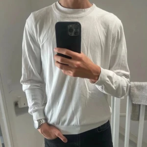 Vit stickad tröja från Boggi Milano - Säljer en stilren vit stickad tröja från Boggi Milano. Tröjan har rund halsringning, ribbade muddar och är långärmad. Perfekt för dig som gillar en clean och klassisk look. Materialet är mjukt och lätt, vilket gör den skön att bära.